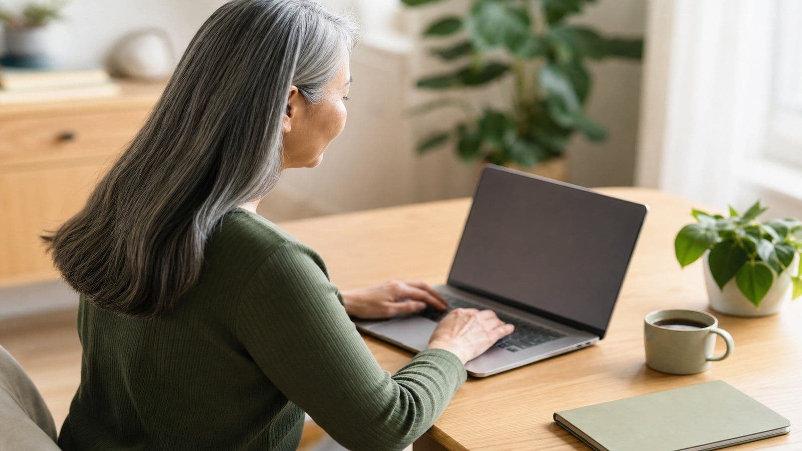 A founder reviews her books from a calm home office